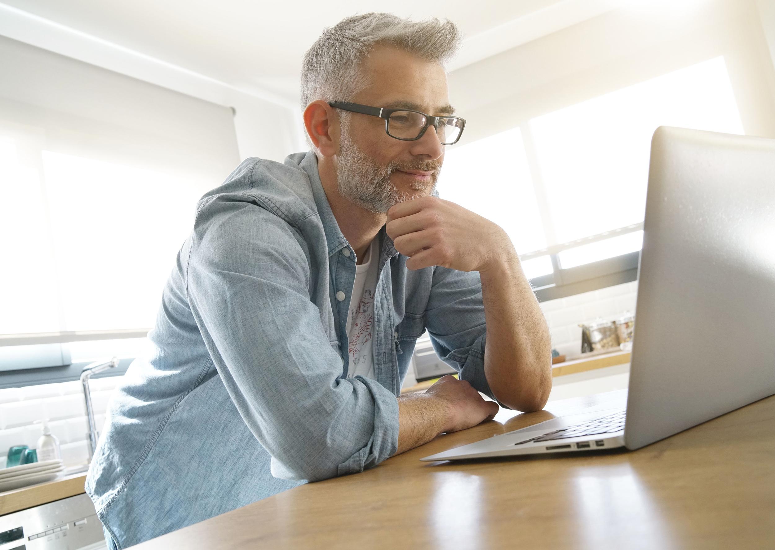 Person vid laptop automatiska solskydd rullgardiner på fönster