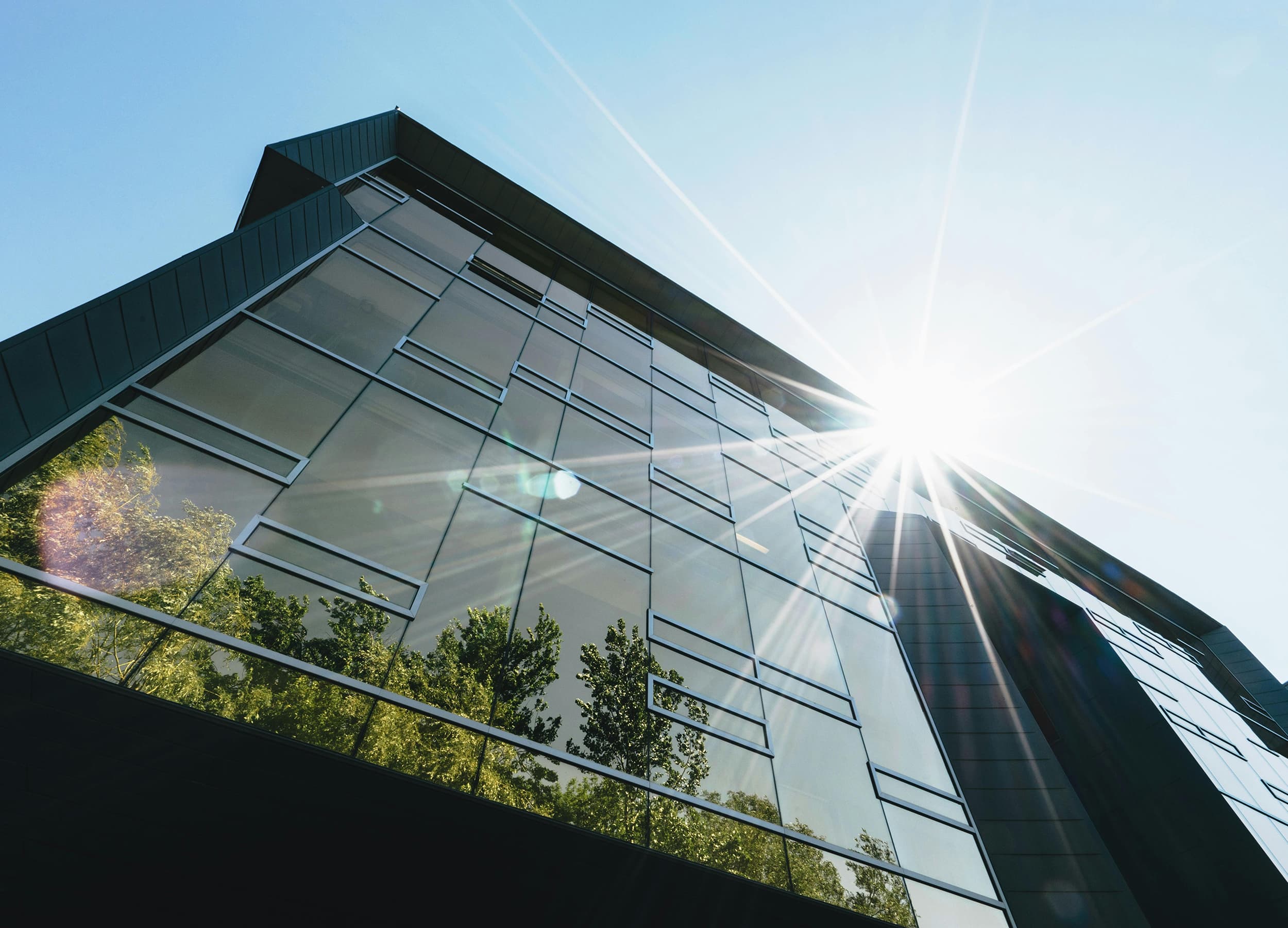 Byggnad solinstrålning värme stäng ute med solskydd Sol strålar in byggnad stora glas fönster solvärme minskar med solavskärmning